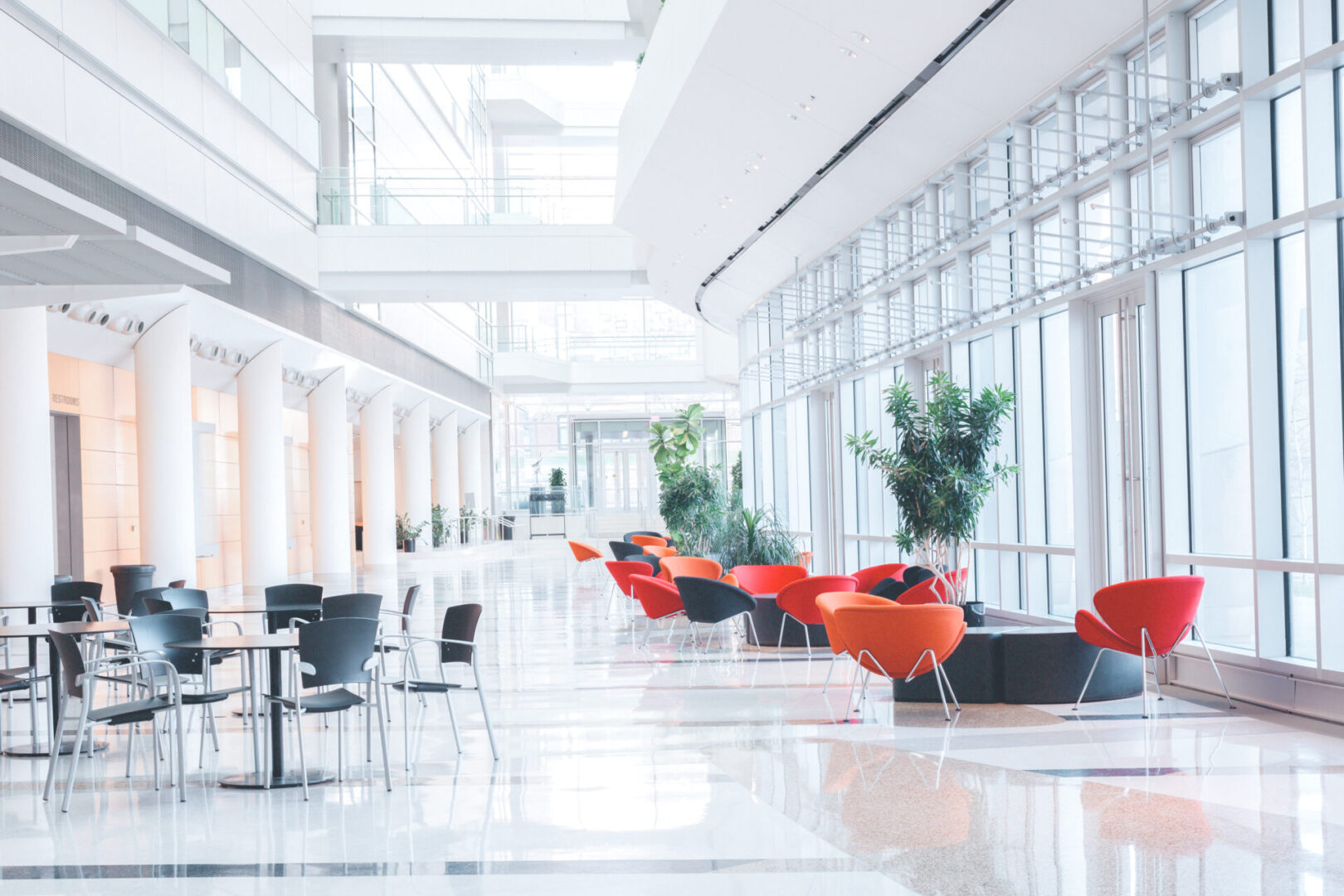 A long hallway with chairs and tables in it