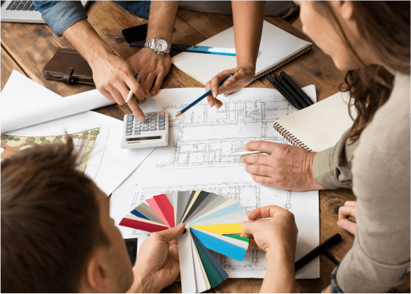 A group of people sitting around a table with papers.