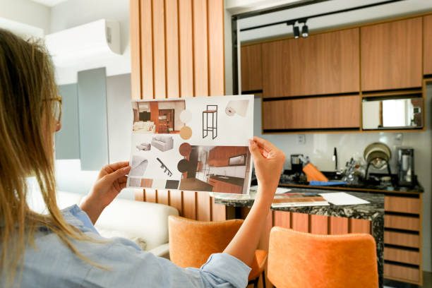 gettyimages-1372401378-612x612 Person reading a magazine in a modern kitchen.