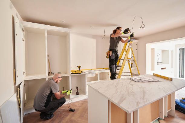 female electrician working in a kitchen remodelling Two people working on electrical wiring in a modern kitchen.